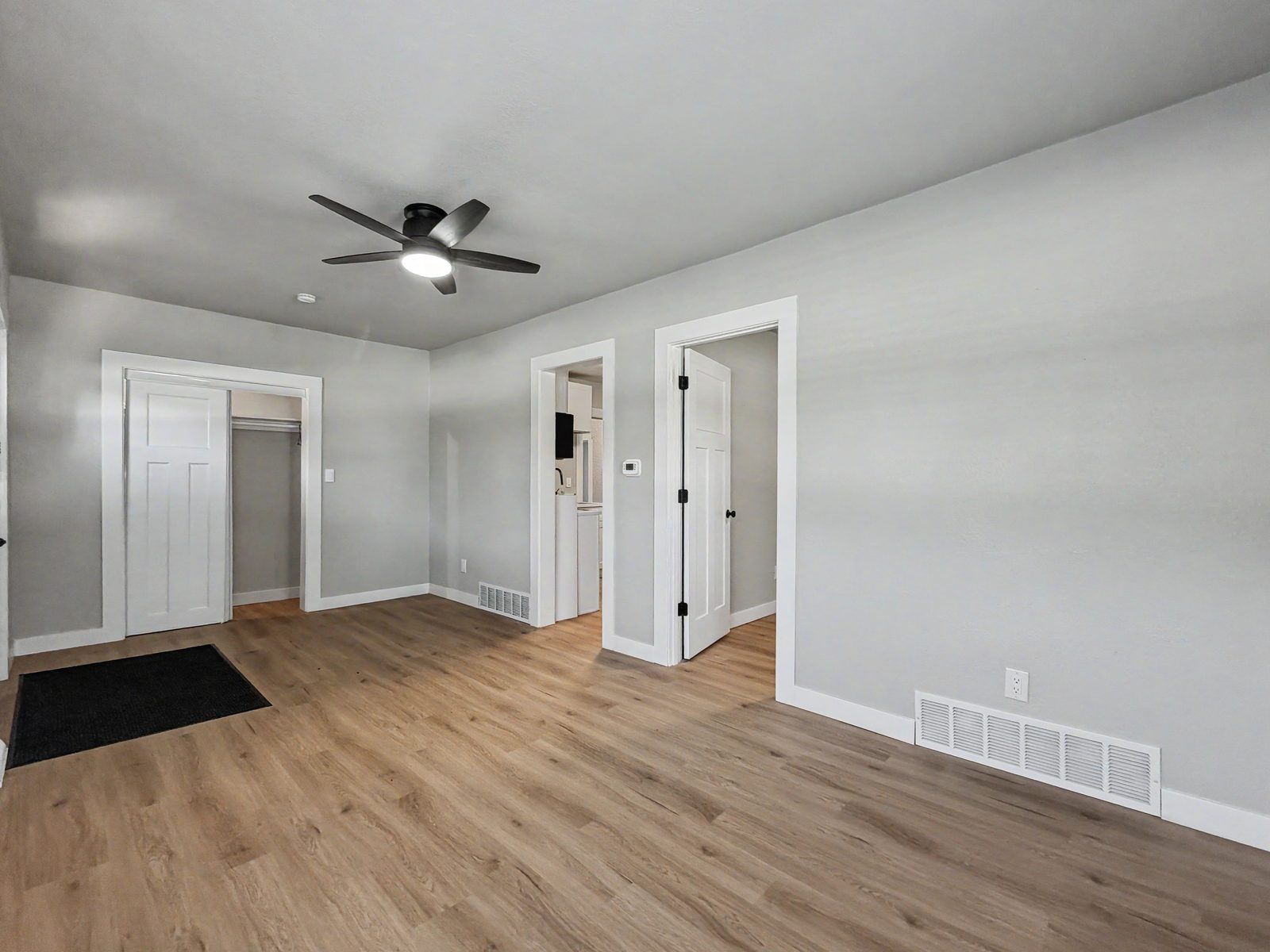 Living room with LVP flooring and view to kitchen in move-in ready ranch Des Moines Iowa