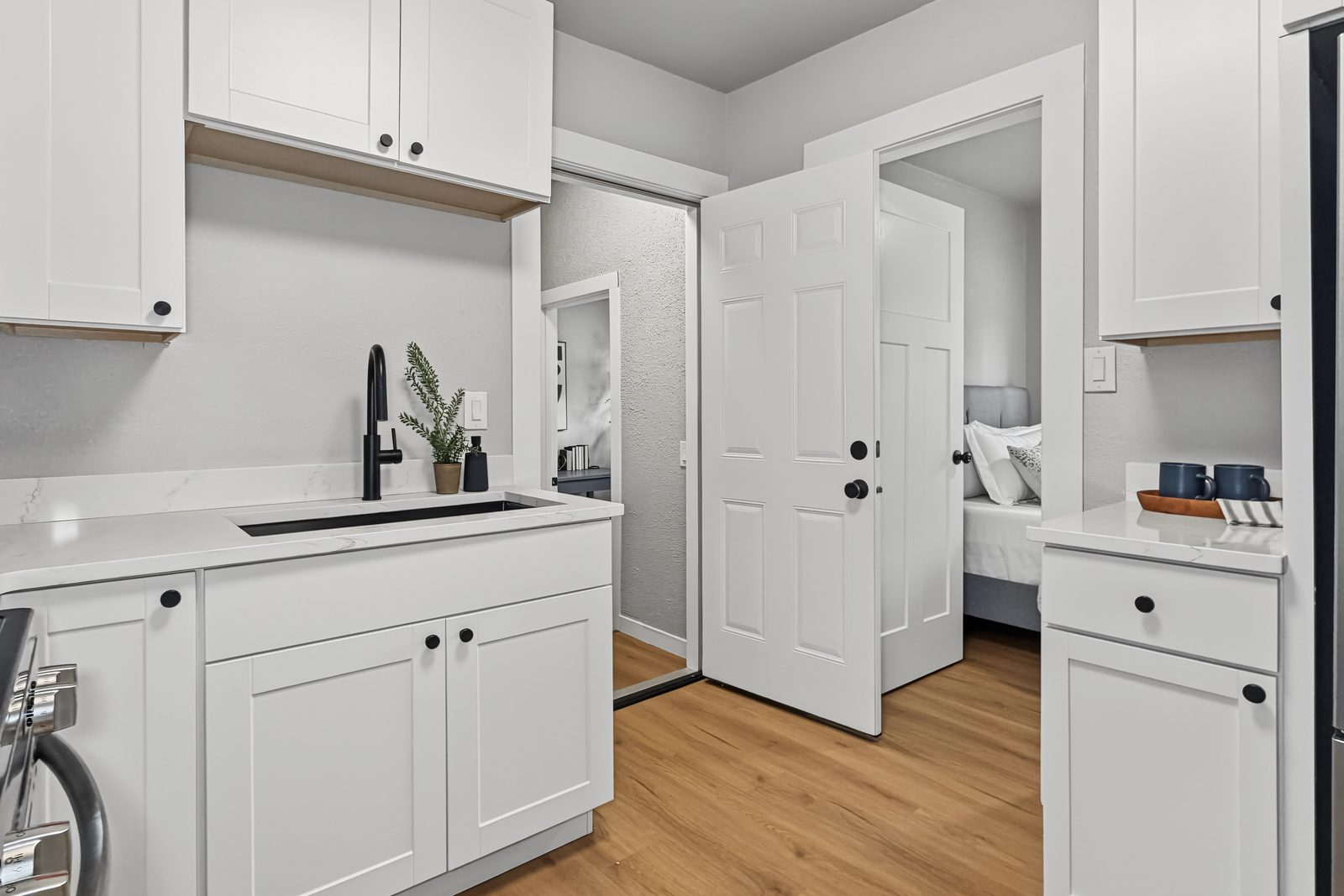 Kitchen sink with matte black faucet and view to the laundry and bedroom at 3436 Scott Ave Des Moines Iowa