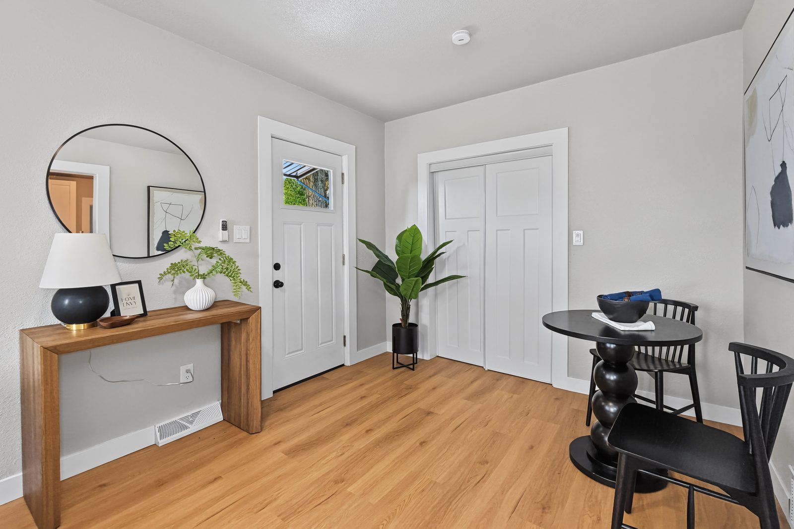 Front entry with console table, round mirror, and dining table at 3436 Scott Ave Des Moines Iowa 50317